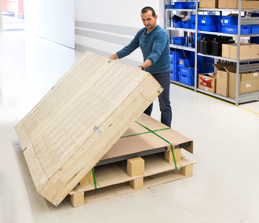 Mand der pakker et produkt ned i en stor kasse.